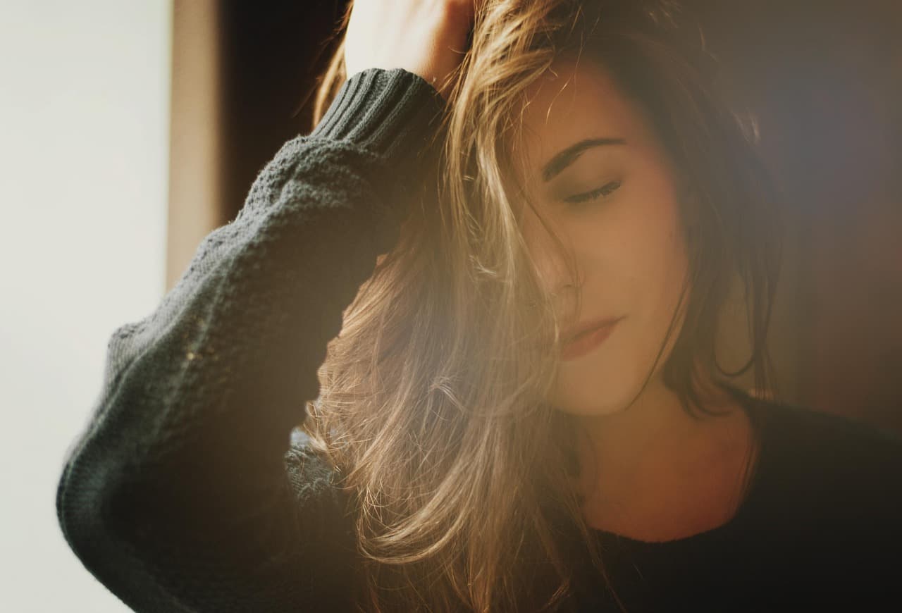 A woman resting by a window in morning light
