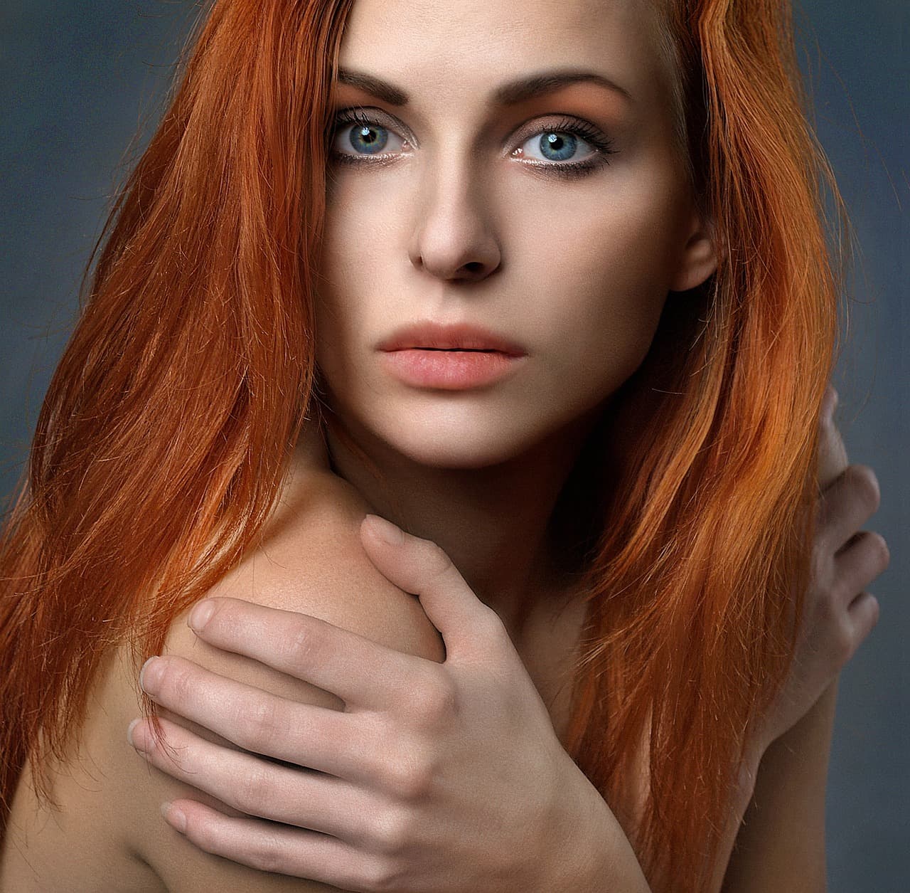 A woman with red hair, her face in soft light