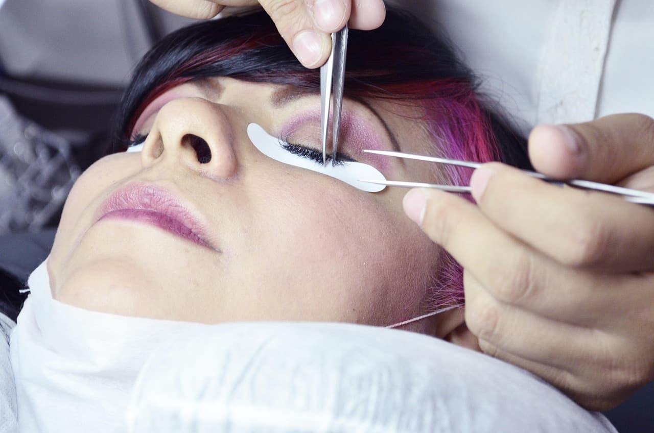 Lash extensions being applied with fine tweezers