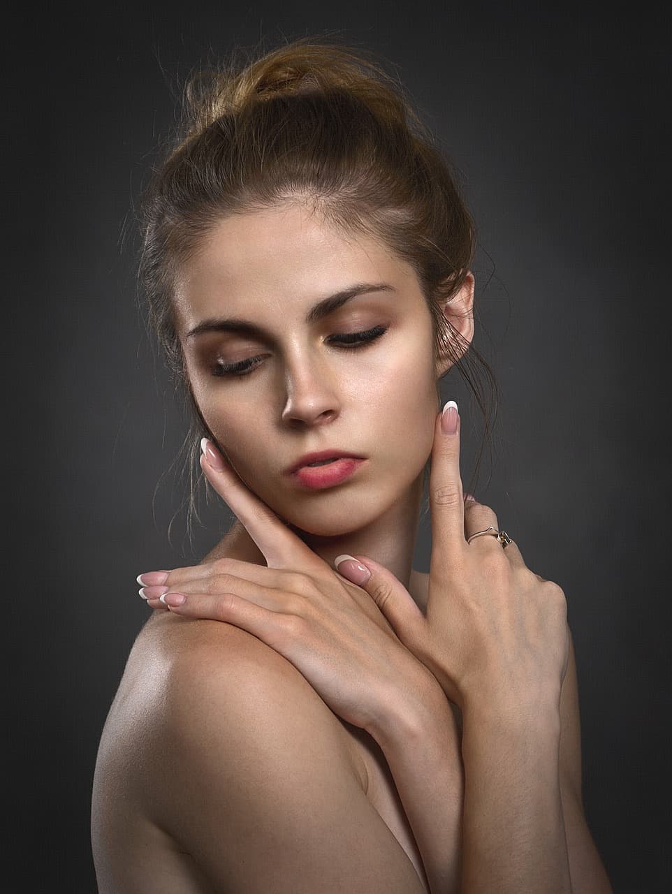 A woman with calm, glowing skin, her hands framing her face