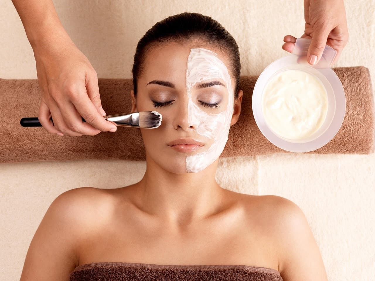 A face mask being brushed on during a facial